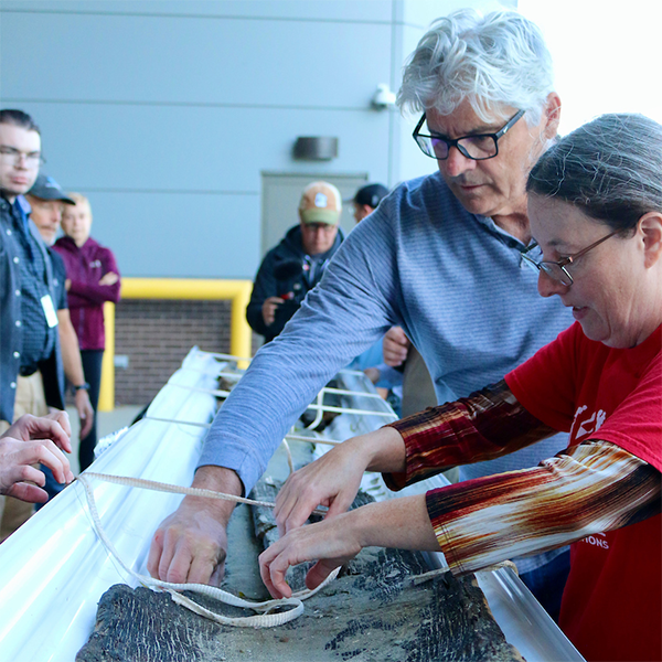 Jim and another woman examine the canoe.